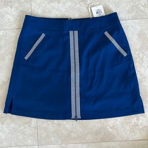Navy golf skort, with classic detail. Super cute. NEVER WORN with tags. Size 8.